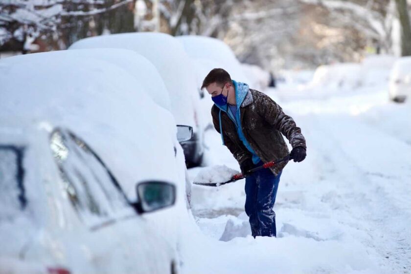 Michael Svabek tries to dig out a car Tuesday after parts of Chicago were buried under about 18 inches of snow.