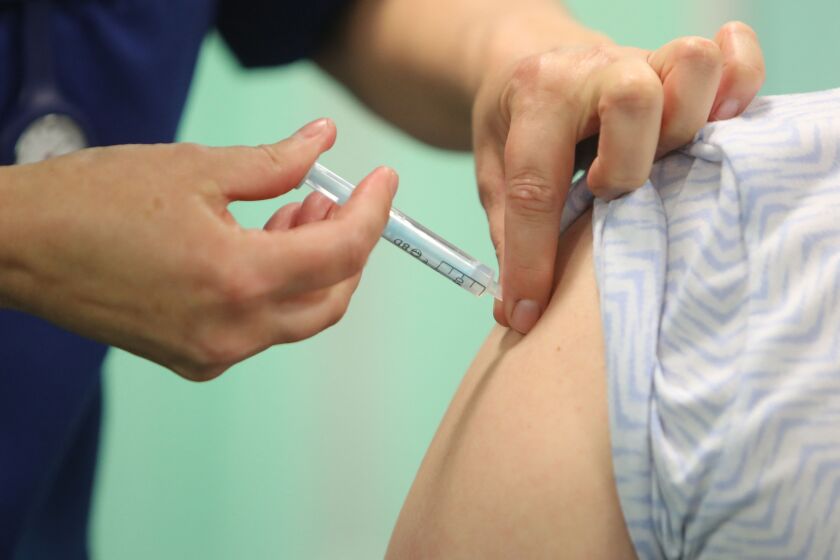 A healthcare professional administers an injection of the Moderna COVID-19 vaccine at a vaccination center.