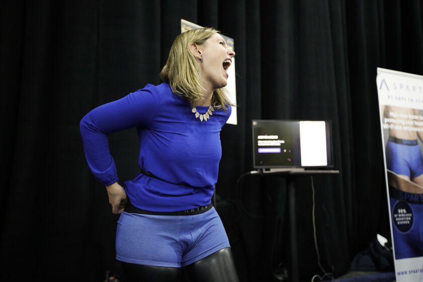 Mariana Marcaletti laughs as she tries on a Spartan boxer, an underwear that blocks radiation from wireless devices, during CES Unveiled at CES International Sunday, Jan. 7, 2018, in Las Vegas. | AP Photo
