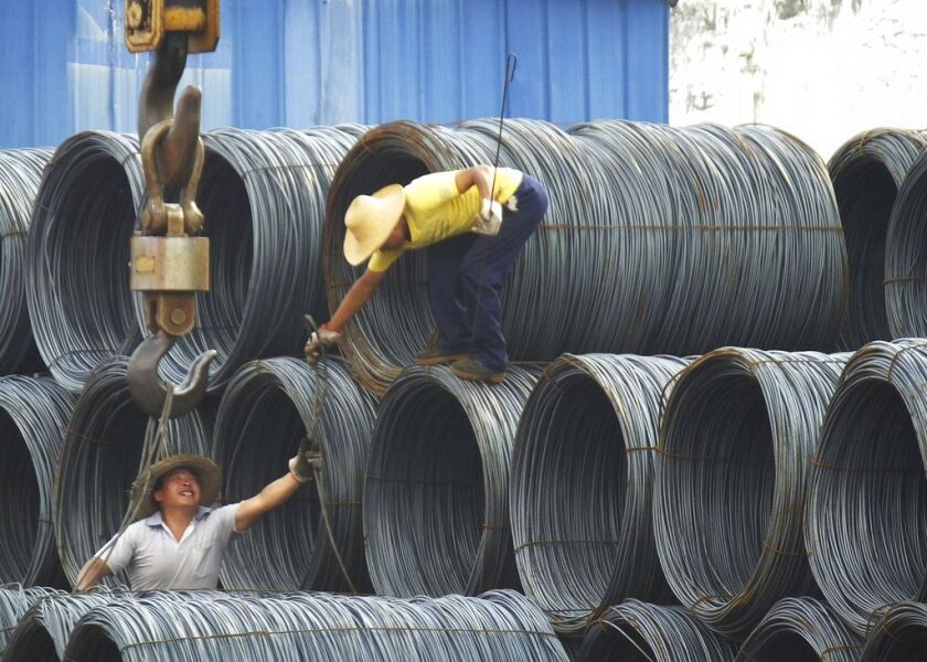 Laborers work in the steel market in Yichang in central China’s Hubei province.(Chinatopix Via AP, File)