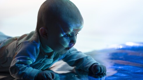 Maisie Seliga looks at her reflection during “RAIN: for babies and their Carers” at Filament Theatre in Portage Park on Wednesday.