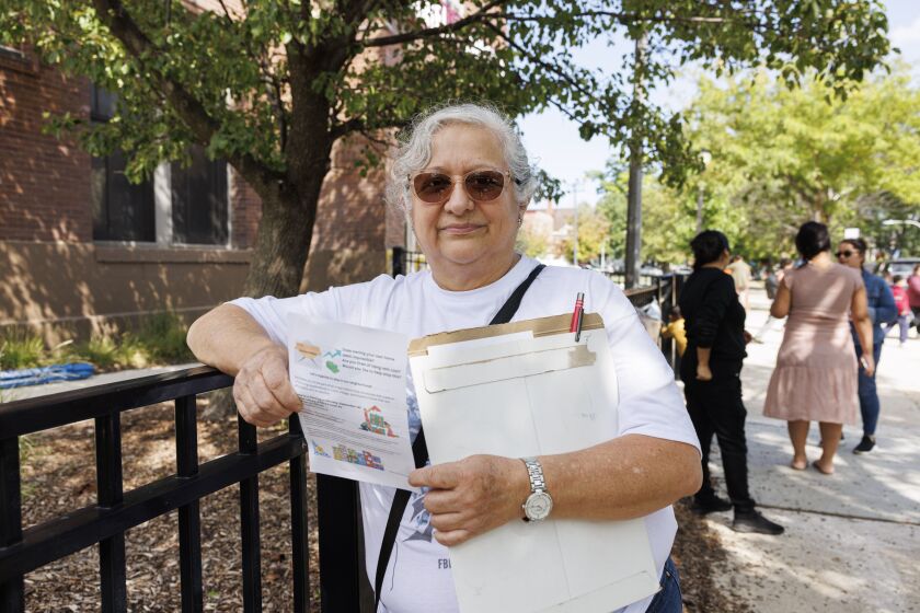 Maria de la Luz Rodriguez hands out fliers this week for a community meeting for Cooperativa La Villita in Little Village. The group aims to explore starting their own housing “cooperative” in the neighborhood as a means to fend off gentrification and displacement.