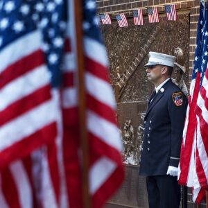 A New York City firefighter stands at attention by a memorial at the side of a firehouse adjacent to One World Trade Center and the 9/11 Memorial site during ceremonies on the anniversary of 9/11 terrorist attacks in New York on Tuesday, Sept. 11, 2018. |