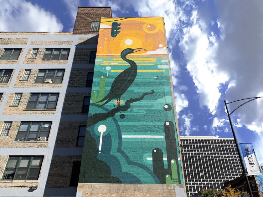 A vertical mural shows a large dark green bird standing in front of a turquoise sea and orange sky.