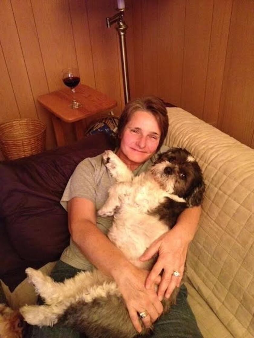 Nancy Lipman with her “little guy,” a dog named Remi she found in a park.