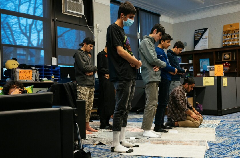 A group of Muslim students pray in the library at Sullivan High School in Rogers Park.