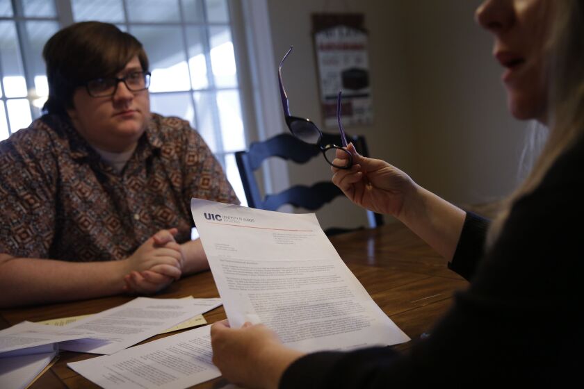 Cynthia Mallard and her son Luke with documents from his UIC case file. | Joshua Lott / ProPublica Illinois