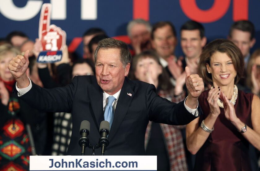 With his wife, Karen, at his side, Republican presidential candidate Gov. John Kasich, R-Ohio, gets cheers from supporters Tuesday at his primary night rally in Concord, N.H. | Jim Cole/AP