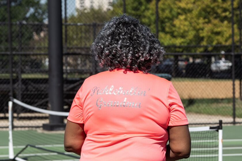 Kassandra Scott shows off her shirt that reads, “Pickleballin’ Grandma” while playing pickleball at Mandrake Park on the South Side, Wednesday, Aug. 31, 2022.