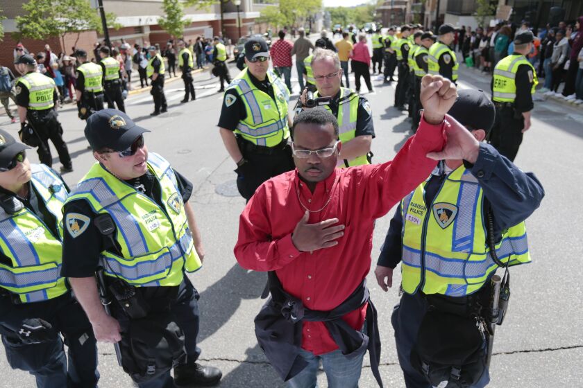 <small><strong>A man is asked by police officers to move from the street before being handcuffed during a protest in Madison, Wis., Wednesday, May 13, 2015. | M.P. King / Wisconsin State Journal via AP</strong></small>
