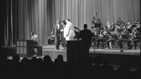 Daddy-O-Daylie, Gloria Lynne, and Leo Gooden singing on stage to Oliver Nelson Orchestra and organist Jimmy Smith at the Arie Crown Theater, Chicago, Illinois, March 20, 1964.