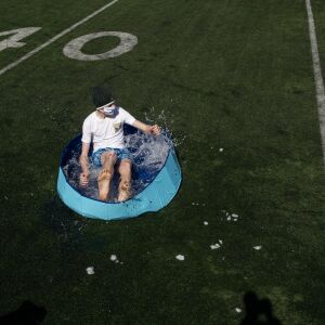 A student jumps into a wading pool filled with snow and water for St. Patrick High School’s version of the Polar Plunge.