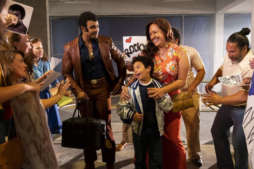 This image released by NBC shows Joseph Lee Anderson as Rocky Johnson (from left), Adrian Groulx as Dwayne and Stacey Leilua as Ata Johnson in a scene from “Young Rock.”