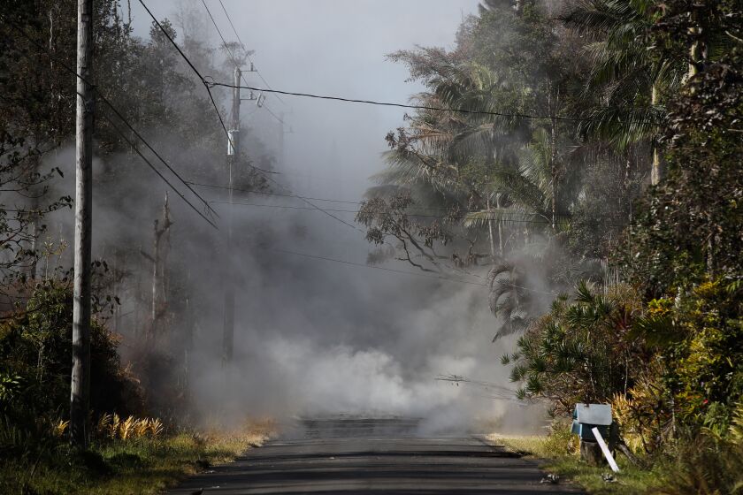Toxic gases rise from cracks in the Leilani Estates subdivision near Pahoa, Hawaii, on Friday. Lava from the Kilauea volcano has destroyed at least 36 structures, including 26 homes. | Jae C. Hong/Associated Press