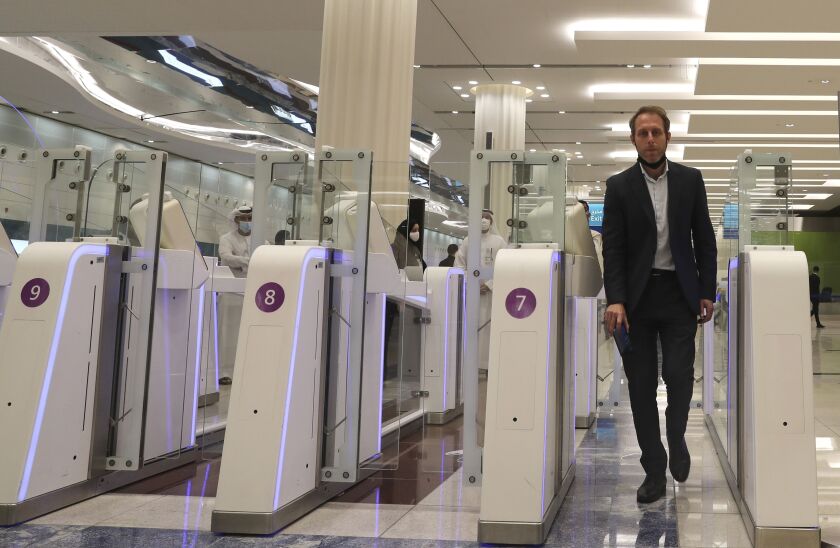 A man goes through an automated gate after he passed through the face and iris-recognition gate to board a plane at Dubai International Airport in the United Arab Emirates,