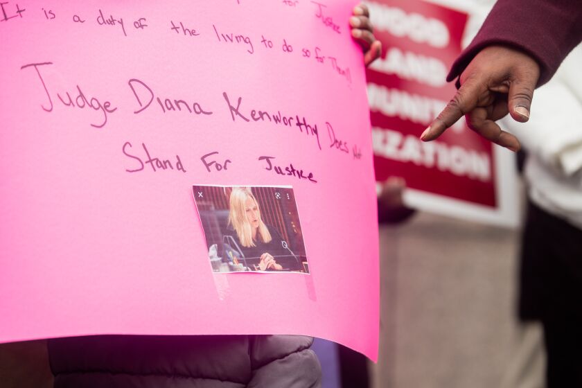 The Rev. Robin Hood points to a picture of Cook County Judge Diana Kenworthy on Tuesday at the Leighton Criminal Courthouse as family and friends of Daisy Hayes, a 65-year-old woman believed to have been murdered in 2018, expressed their frustration with Kenworthy after the judge found the man accused of killing Hayes not guilty last week.