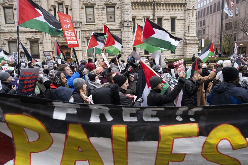 Protesters wave Palestinians flags as they march during a Black Friday protest on the Magnificent Mile on Nov. 24, 2023.