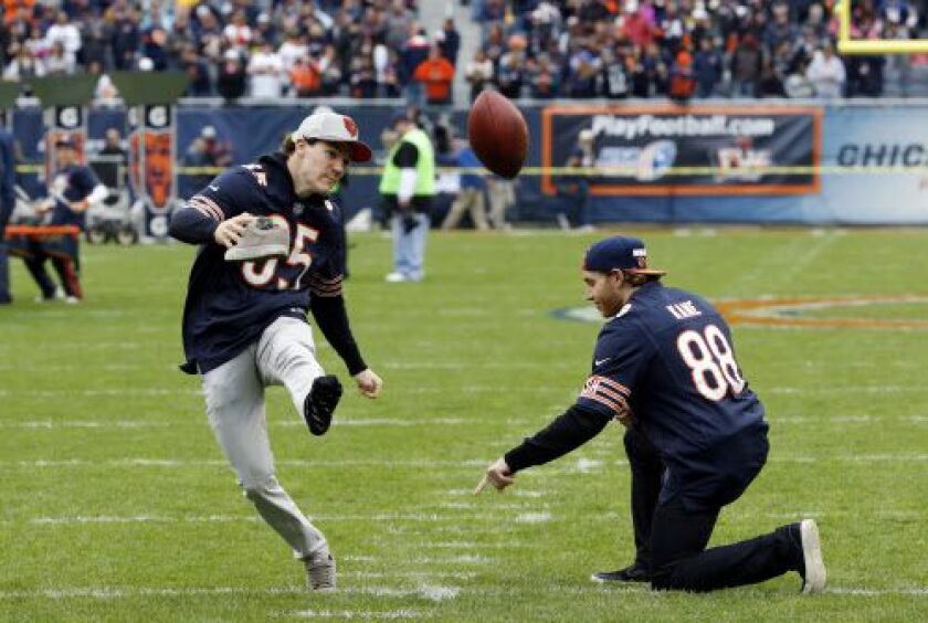Patrick Kane holds the football as teammate Andrew Shaw tries to kick in before the Bears’ game Sunday. (AP)