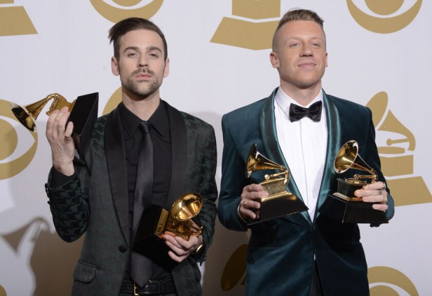 In this Jan. 26, 2014 file photo, Ryan Lewis (left) and Macklemore pose in the press room with their awards for best rap performance and best rap song, for “Thrift Shop,” best rap album for “The Heist” and best new artist at the 56th annual Grammy Awards