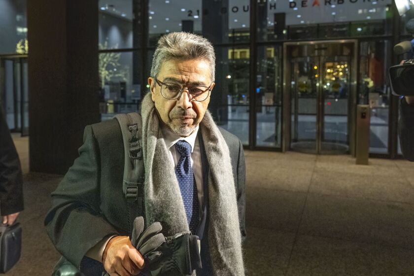 Former Ald. Danny Solis walks towards a waiting vehicle outside the Dirksen Federal Building Monday.