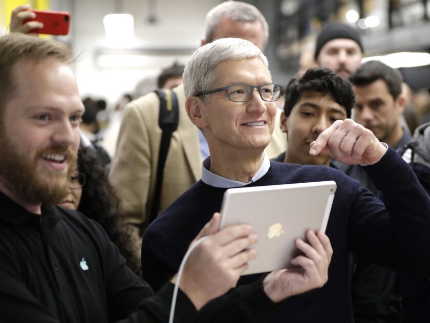 Apple CEO Tim Cook shows off an iPad at Lane Technical College Prep High School in Chicago in March. | Charles Rex Arbogast/AP