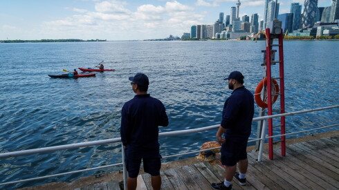 People look out across Lake Ontario from the harbor in Toronto, Tuesday, Aug. 25, 2026.