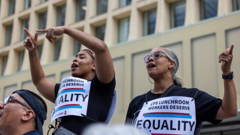Two people chant at a protest in support of Chicago Public Schools lunchroom workers.