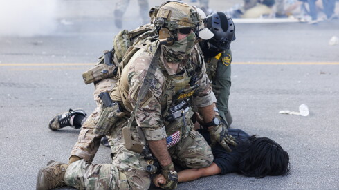 Federal officers hold down a protestor in Brighton Park on the Southwest Side on Oct. 4, 2025.