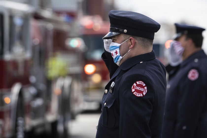Chicago Fire Department personnel salute during the procession to the cemetery from firefighter Mario Araujo’s funeral at Theis-Gorski Funeral Home on the Northwest Side, Monday morning, April 13, 2020.