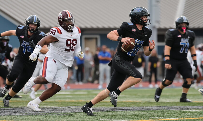 Lincoln-Way East's Evan Lefevour (10) scrambles out of the pocket as he attempts a pass against Brother Rice.