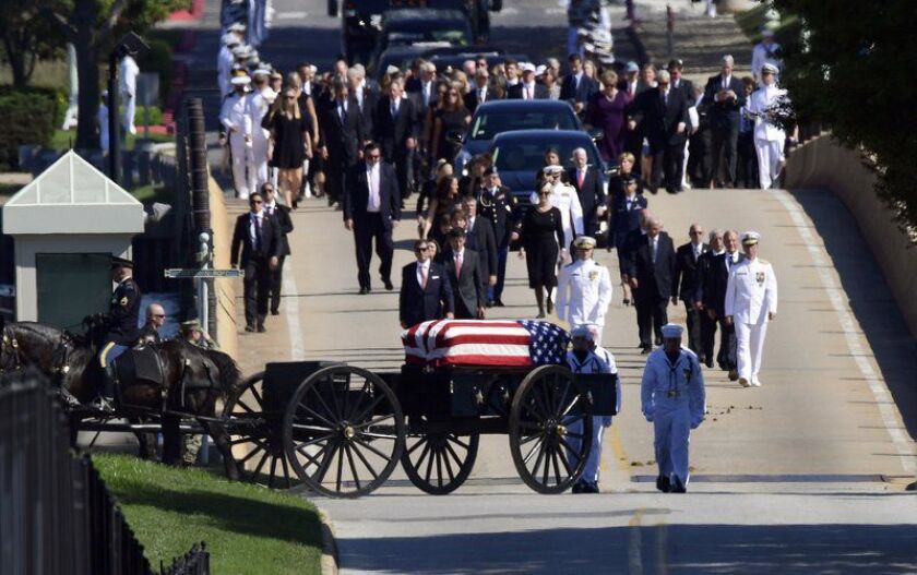 Family members, including Cindy McCain, back center, follow a horse-drawn caisson that carries the casket of Sen. John McCain, R-Ariz., as it proceeds to the United States Naval Academy cemetery in Annapolis, Md., Sunday, Sept. 2, 2018, for burial. McCain