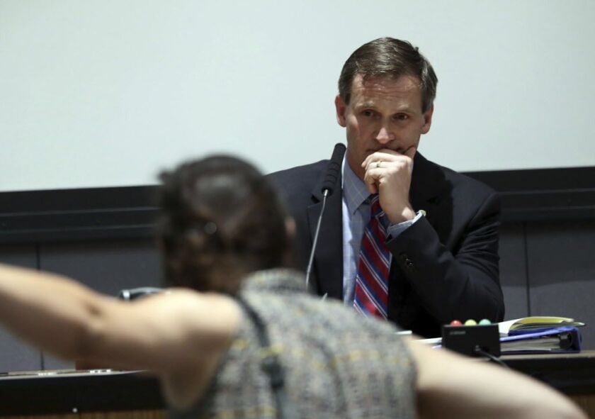 A protester yells as Mayor Mike Signer listens during the Charlottesville City Council meeting on Monday. | Andrew Shurtleff/The Daily Progress via AP