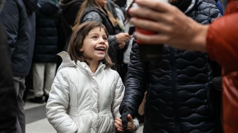 Julieta Vincentelli, 6, gave her dad a break from sitting on his shoulders and smiles while walking on West Washington Street near North State Street during the Thanksgiving Day parade. She are her family are visiting Chicago from Memphis.