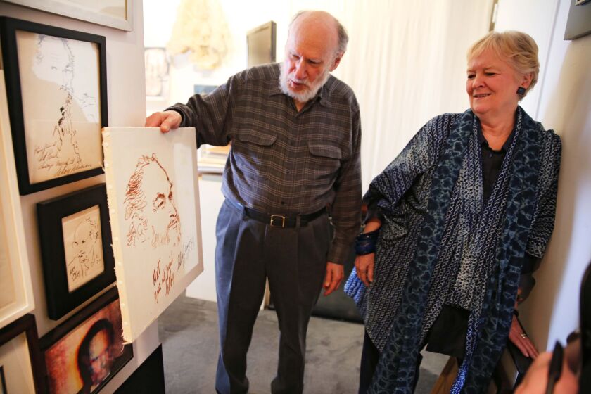 Art Paul and wife Suzanne Seed at their Gold Coast home in 2014, showing off a collection of portraits of himself painted by famous artists. | Chandler West | Sun-Times