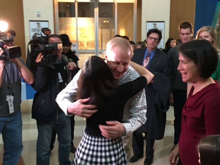 Republican Gov.-elect Bruce Rauner hugs Democratic Attorney General Lisa Madigan on Sunday as Rauner’s wife, Diana, looks on. Photo by Jon Seidel.