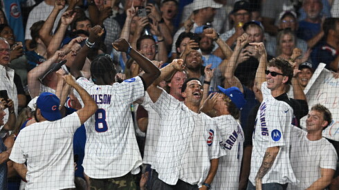 Chicago Bears quarterback Caleb Williams, center, Chicago Bulls players Caleb Wilson, left, and Matas Buzelis. right, along with music video director Cole Bennett, second from right, cheer during the seventh inning of a baseball game between the Chicago Cubs and Milwaukee Brewers in Chicago, Thursday, Sept. 3, 2026.