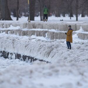 A woman looks out at a frozen Lake Michigan, near the Foster Ave. Beach along the lakefront, Wednesday, Feb. 3, 2021.