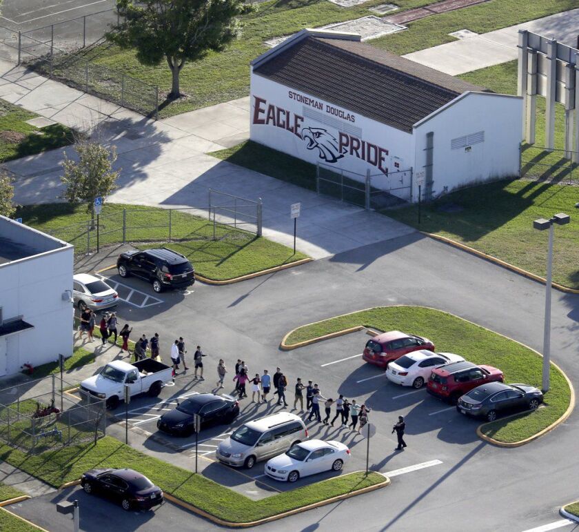 Students are evacuated by police from Marjory Stoneman Douglas High School in Parkland, Fla., on Wednesday after a shooter opened fire on the campus. | Mike Stocker/South Florida Sun-Sentinel via AP