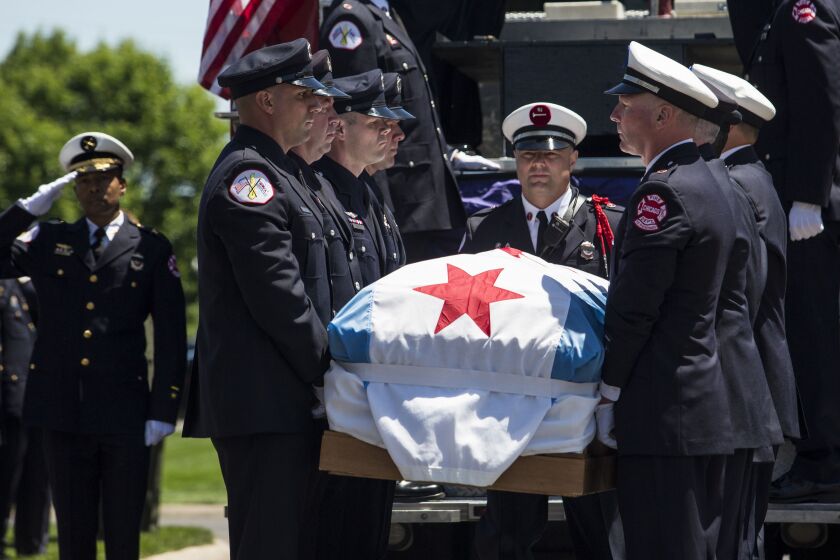 Firefighters lift Juan Bucio’s casket off a fire truck for his funeral at St. Rita of Cascia High School. | Ashlee Rezin/Sun-Times