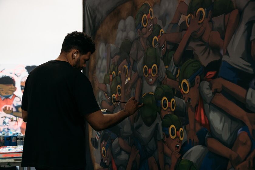 Artist Hebru Brantley at work in his studio. Drawing on comic books, Japanese anime and his own street-art roots, Brantley uses his signature, pop-infused characters, Flyboy and Lil Mama, to address a range of socio-political issues. | MAX SCHREIER