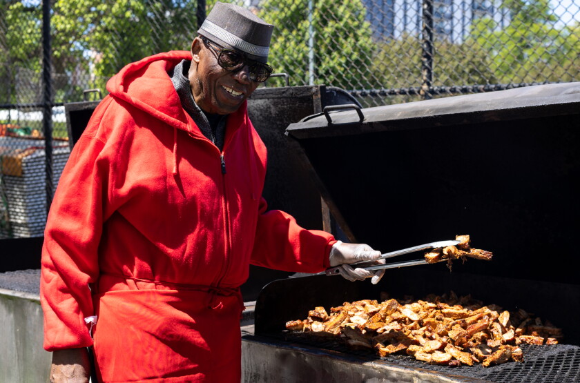 Robinson’s #1 Ribs owner tosses meat on the grill.