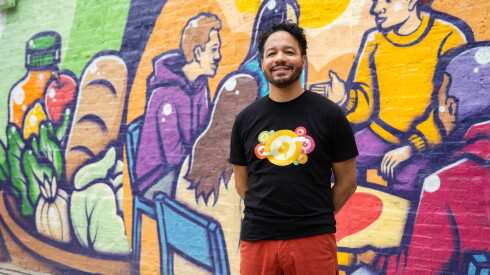 Anthony Lewellen stands in front of his mural “Radiating Hope” outside the Nourishing Hope’s Sheridan Market location in Lake View.