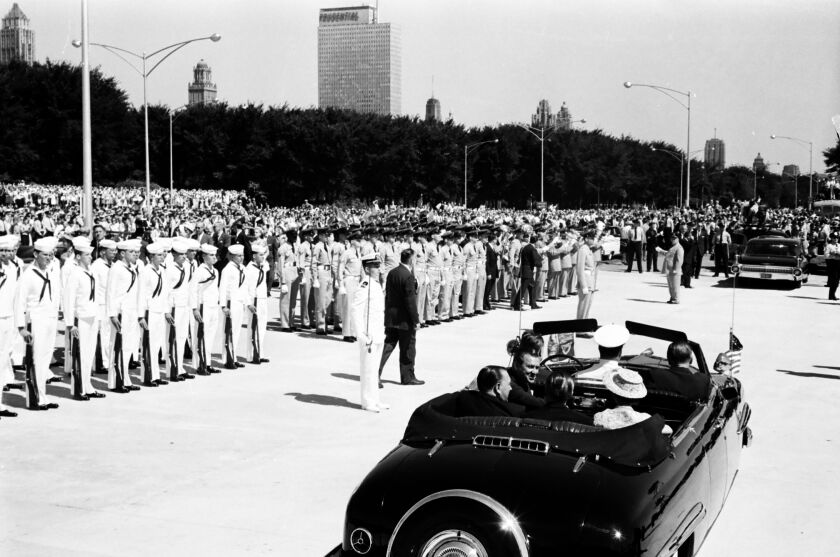 Queen Elizabeth and Prince Phillip board cars to travel into the city.