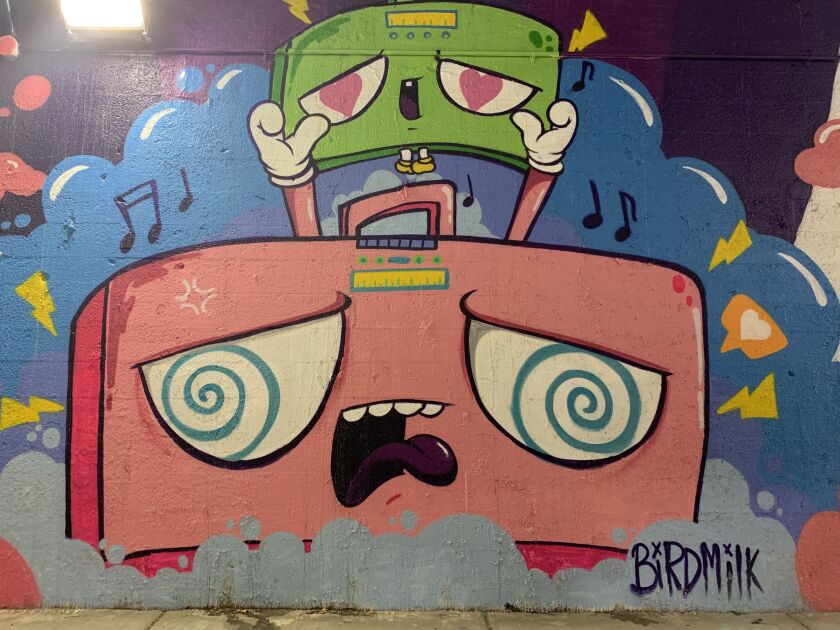 This mural, by the Pilsen artist known as “Bird Milk,” shows an “older” boombox lifting up a younger, smaller one. The idea is of “having your voices heard and holding each other up” while helping “the younger generations get their voices out there.”