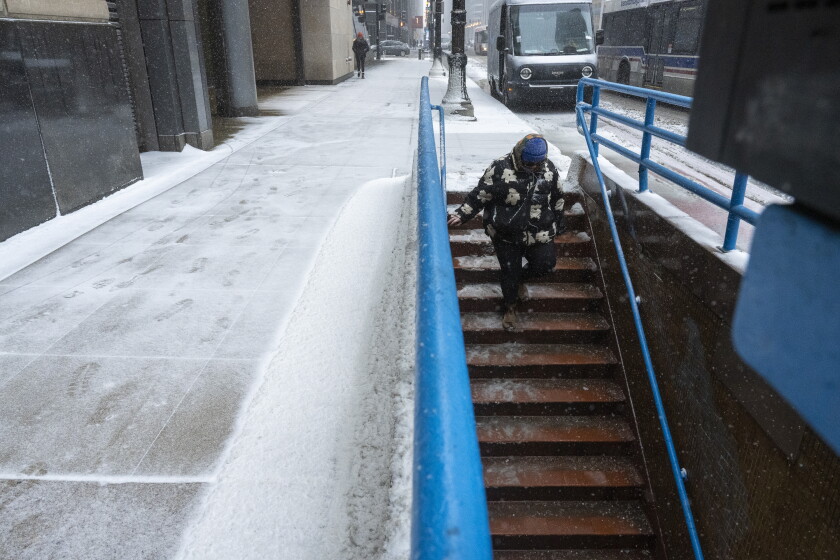 2025年2月12日水曜日、シカゴ地域を雪が降ると、女性が階段を下ってトイレのワシントンブルーラインステーションに向かいます。タイラー・パシアック・ラリヴィエール/太陽 - タイムズ