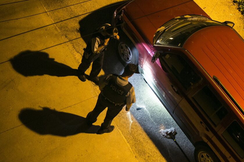 A Chicago Police Officer looks for shells casings after two men were fatally shot early Tursday in the 6600 block of South Evans. | Justin Jackson/Sun-Times