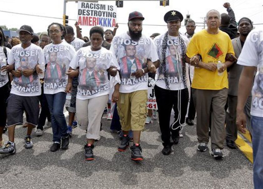 Michael Brown Sr. (center) leads a march in remembrance of his son, Michael Brown on Sunday, Aug. 9, 2015, in Ferguson, Missouri. | Jeff Roberson/AP