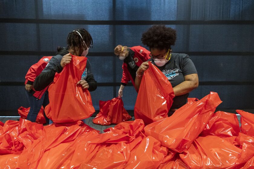 AmeriCorps members from City Year Chicago double-check bag of donated school supplies that were sorted and packed up at Wintrust Arena on Monday, Jan. 18, 2021. It was one of several projects on Monday that were part of a national day of service on Martin Luther King Jr. Day. The supplies will be distributed to five Chicago Public Schools before the return of in-person learning.