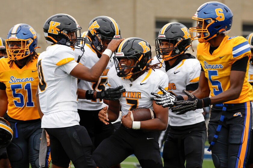 King’s Emmanuel James (7) is celebrated by teammates during the game against Simeon at Stagg Stadium.