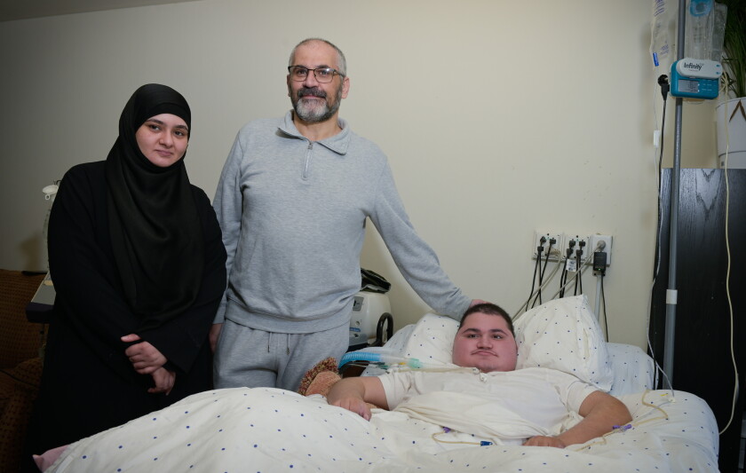 Syrian refugees Asmaa and Mahmoud poses with their disabled son Omar.